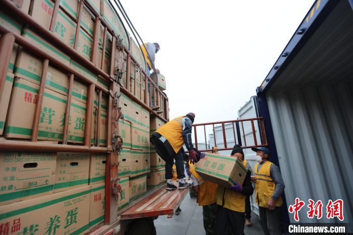 圖為鐵路裝卸作業(yè)人員正在將云南特色農(nóng)產(chǎn)品裝入集裝箱?！詈?攝