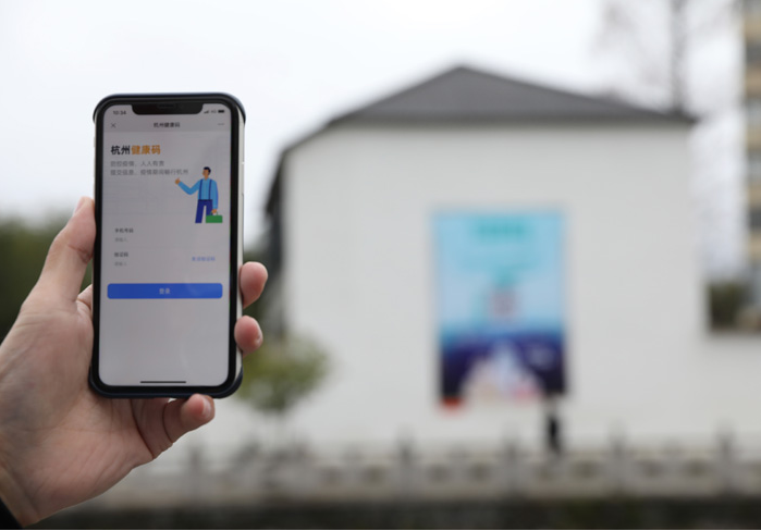 在浙江省杭州市臨安區(qū)天目山鎮(zhèn)，一名居民在“杭州健康碼”海報上掃碼申領(lǐng)個人二維碼。新華社發(fā)