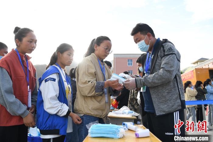 7月7日，考生在拉薩三高考點外領取口罩。　何蓬磊 攝