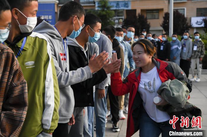 7月7日，拉薩三高考點外，領隊老師與考生擊掌鼓勁加油。　何蓬磊 攝