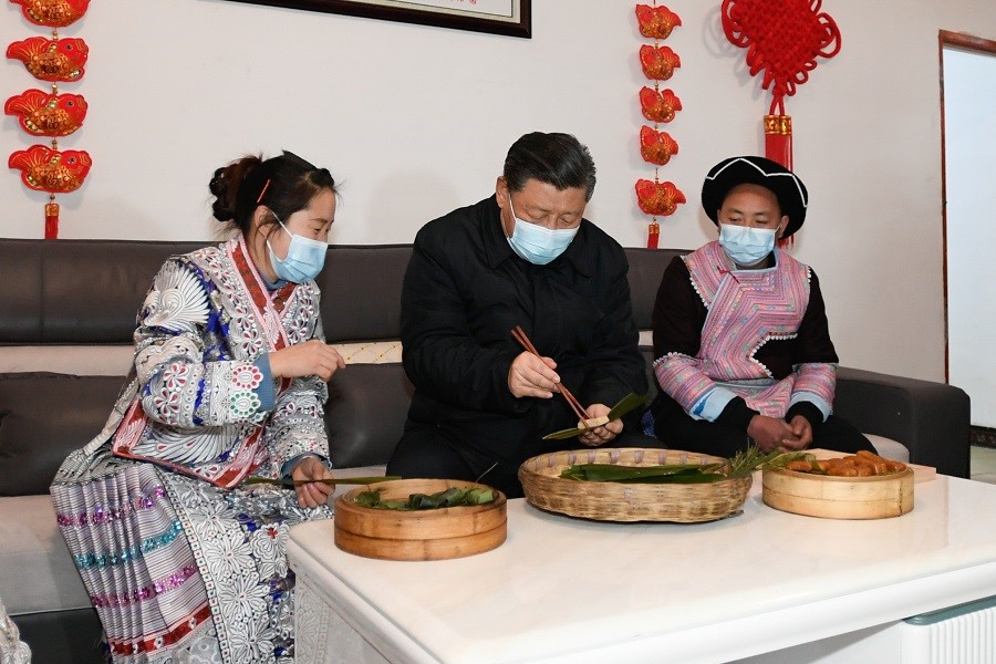 2021年2月3日下午，習近平在貴州畢節(jié)市黔西縣新仁苗族鄉(xiāng)化屋村苗族村民趙玉學家，同一家人邊聊家常邊制作當?shù)貍鹘y(tǒng)節(jié)日食品黃粑。新華社記者 李學仁 攝